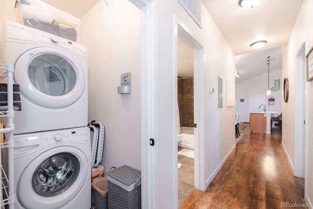 washroom featuring stacked washer / drying machine and wood-type flooring