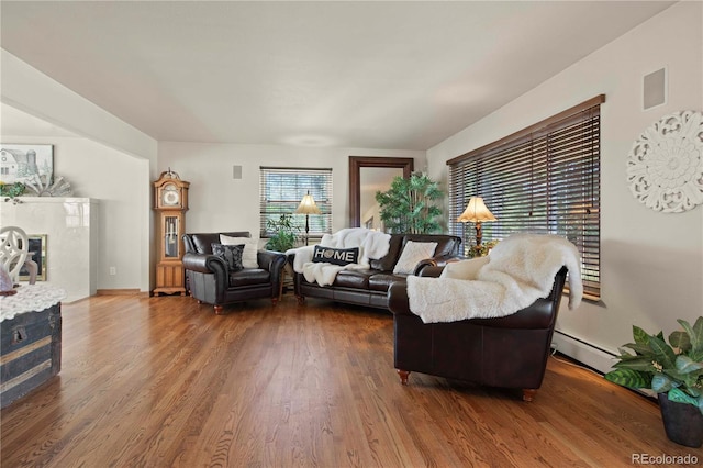6492 S Piney Creek Cir, Centennial, CO 80016 - living area featuring a baseboard radiator, a glass covered fireplace, and wood finished floors