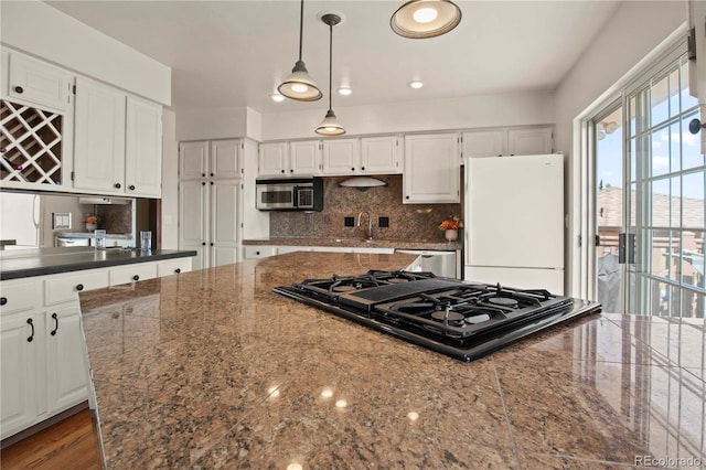 6492 S Piney Creek Cir, Centennial, CO 80016 - kitchen featuring a sink, stovetop with downdraft, stainless steel microwave, white cabinetry, and freestanding refrigerator
