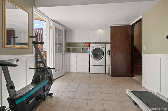 6492 S Piney Creek Cir, Centennial, CO 80016 - laundry area with a decorative wall, wainscoting, separate washer and dryer, light tile patterned floors, and cabinet space