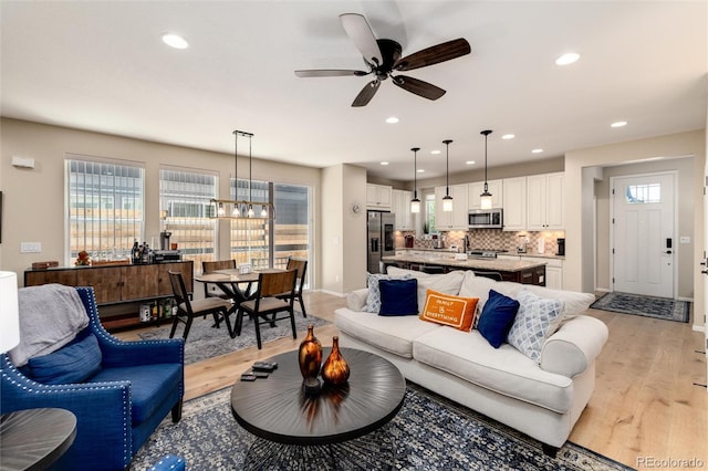 8186 E 53rd Dr, Denver, CO 80238 - living area featuring light wood finished floors, recessed lighting, a ceiling fan, and a chandelier