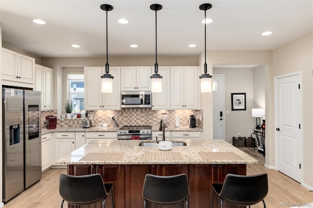 8186 E 53rd Dr, Denver, CO 80238 - kitchen featuring appliances with stainless steel finishes, decorative backsplash, white cabinetry, a breakfast bar area, and recessed lighting
