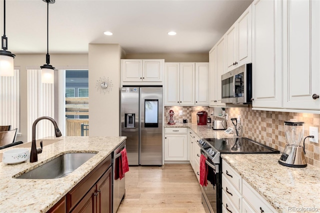 8186 E 53rd Dr, Denver, CO 80238 - kitchen with appliances with stainless steel finishes, white cabinets, light wood finished floors, tasteful backsplash, and light stone counters