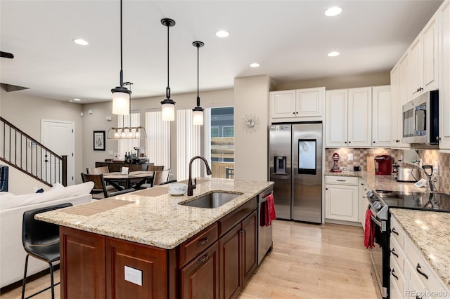 8186 E 53rd Dr, Denver, CO 80238 - kitchen with appliances with stainless steel finishes, white cabinets, recessed lighting, decorative backsplash, and light wood-style flooring