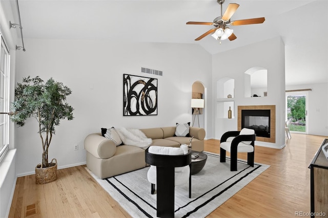 5193 Rustic Ave, Firestone, CO 80504 - living area featuring built in features, light wood finished floors, vaulted ceiling, ceiling fan, and a tile fireplace