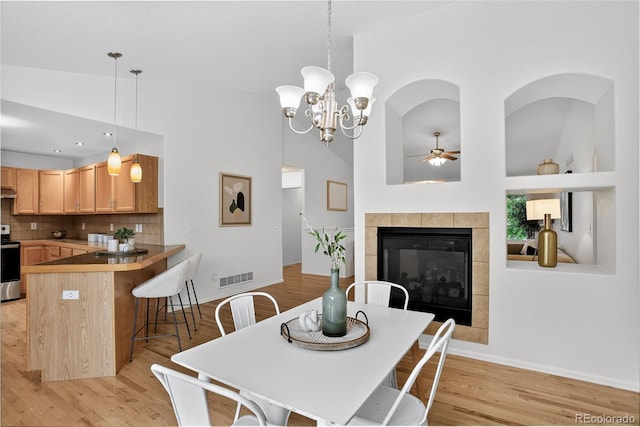 5193 Rustic Ave, Firestone, CO 80504 - dining area with a ceiling fan, light wood-style floors, a tiled fireplace, and a chandelier
