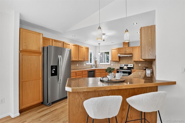 5193 Rustic Ave, Firestone, CO 80504 - kitchen featuring stainless steel appliances, lofted ceiling, tile counters, under cabinet range hood, and backsplash