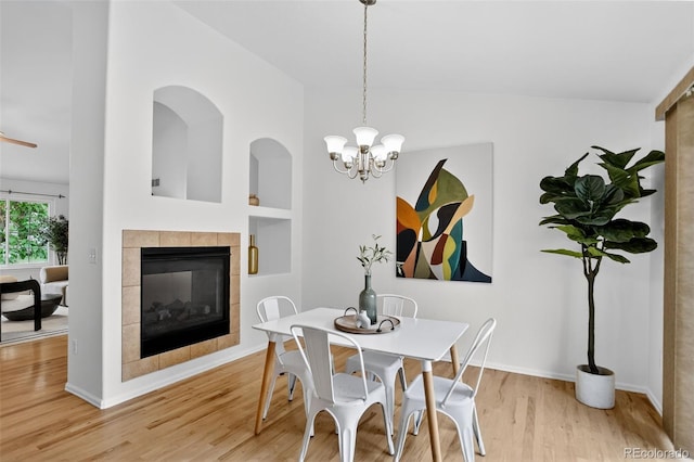 5193 Rustic Ave, Firestone, CO 80504 - dining room featuring wood finished floors, a tiled fireplace, built in shelves, and a chandelier