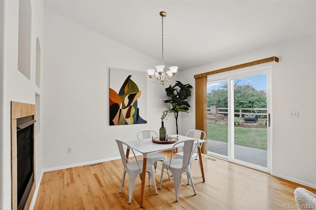 5193 Rustic Ave, Firestone, CO 80504 - dining space with light wood-style floors, a chandelier, lofted ceiling, and a fireplace