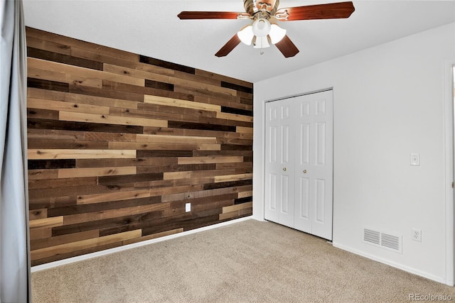 5193 Rustic Ave, Firestone, CO 80504 - unfurnished bedroom with wood walls, carpet floors, a closet, and a ceiling fan