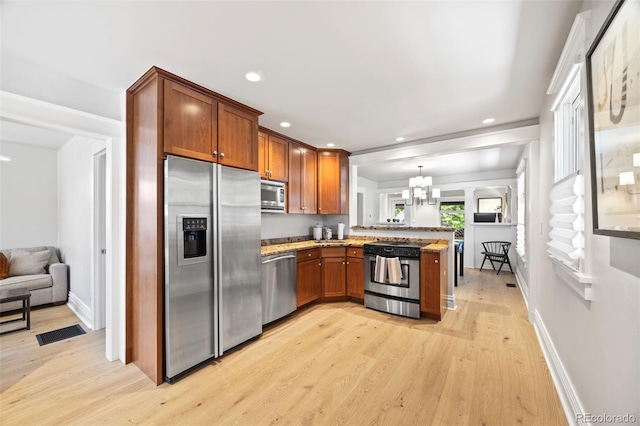 400 S Gilpin St, Denver, CO 80209 - kitchen with stainless steel appliances, a peninsula, light wood-style flooring, light stone counters, and recessed lighting