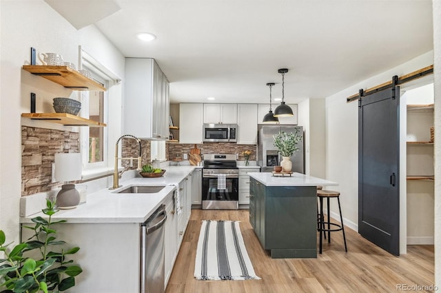 1155 W 4th Ave, Broomfield, CO 80020 - kitchen featuring stainless steel appliances, a sink, a barn door, backsplash, and light countertops