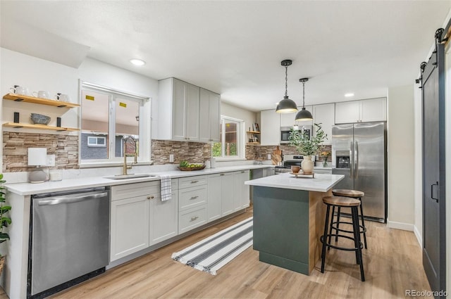 1155 W 4th Ave, Broomfield, CO 80020 - kitchen with stainless steel appliances, open shelves, a sink, a barn door, and decorative backsplash