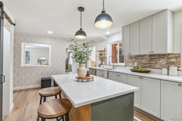 1155 W 4th Ave, Broomfield, CO 80020 - kitchen with a sink, wallpapered walls, dishwasher, light wood-style floors, and a kitchen bar