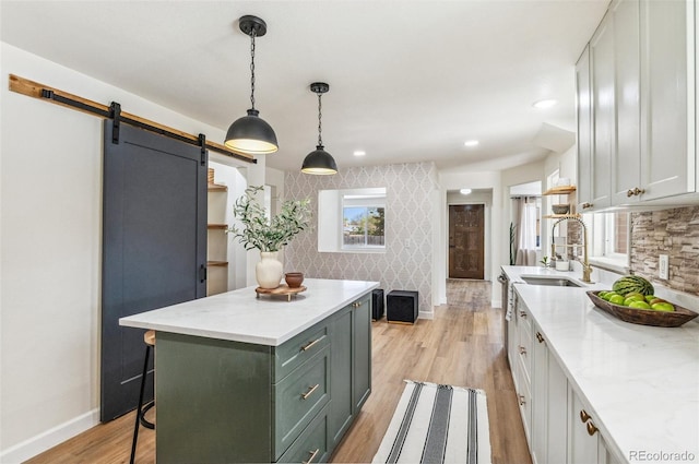 1155 W 4th Ave, Broomfield, CO 80020 - kitchen with a sink, baseboards, light wood-type flooring, a barn door, and a center island