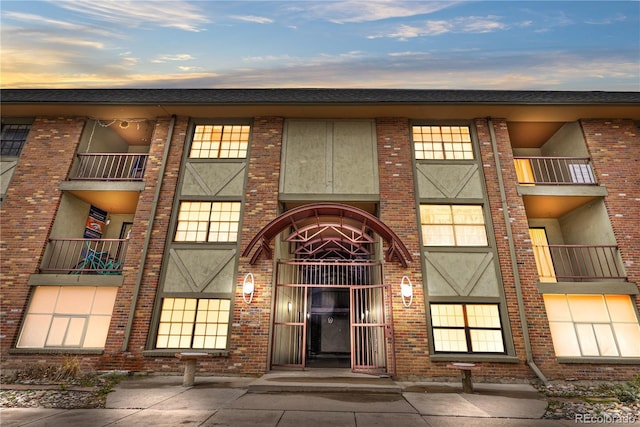property entrance with brick siding and a balcony