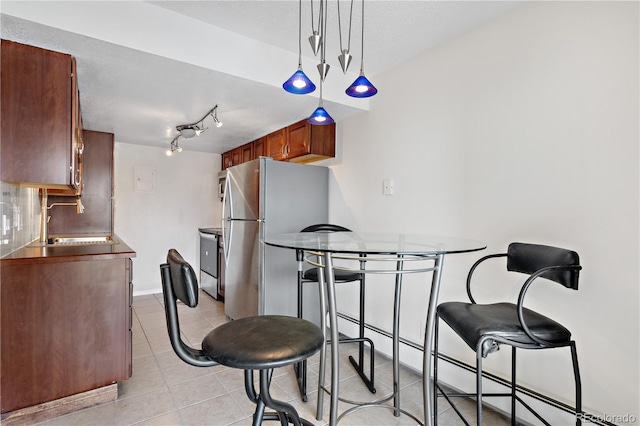 dining space with a textured ceiling and light tile patterned floors