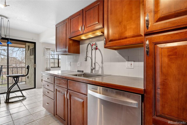 kitchen featuring brown cabinetry, light tile patterned flooring, dishwasher, a sink, and backsplash