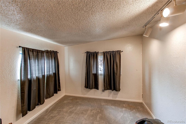 empty room with carpet floors and a textured ceiling