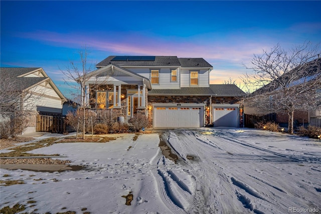 view of front of property featuring a garage and solar panels