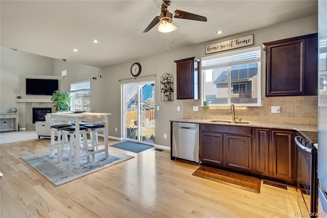 kitchen featuring lofted ceiling, sink, appliances with stainless steel finishes, tasteful backsplash, and light hardwood / wood-style floors