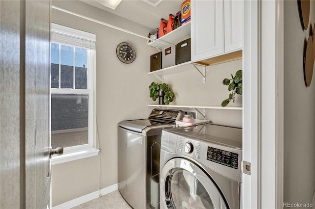 laundry area featuring cabinets, washing machine and dryer, and light tile patterned floors