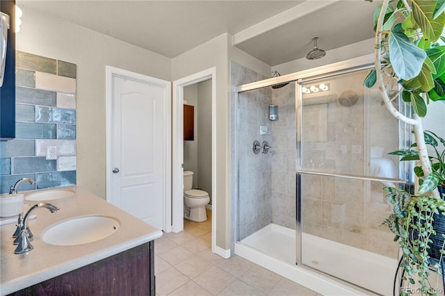 bathroom featuring tile patterned flooring, walk in shower, vanity, and toilet