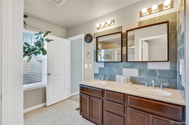 bathroom featuring vanity, backsplash, a shower with door, and tile patterned floors