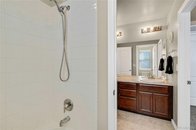 bathroom with tiled shower / bath combo, vanity, and tile patterned floors