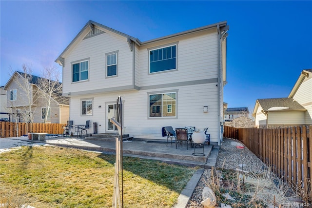 rear view of property with a lawn and a patio