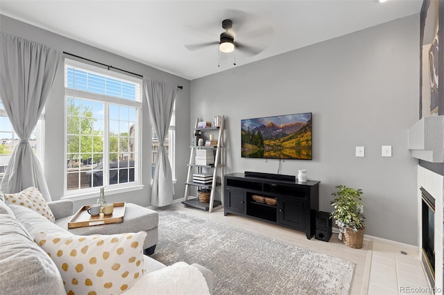 5555 E Briarwood Ave Unit 1404, Centennial, CO 80122 - living area featuring a glass covered fireplace, a ceiling fan, baseboards, and tile patterned floors