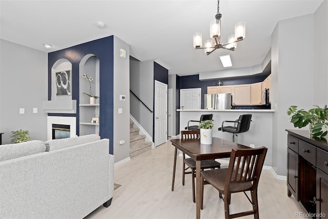 5555 E Briarwood Ave Unit 1404, Centennial, CO 80122 - dining room featuring a chandelier, light wood-type flooring, stairs, baseboards, and a glass covered fireplace