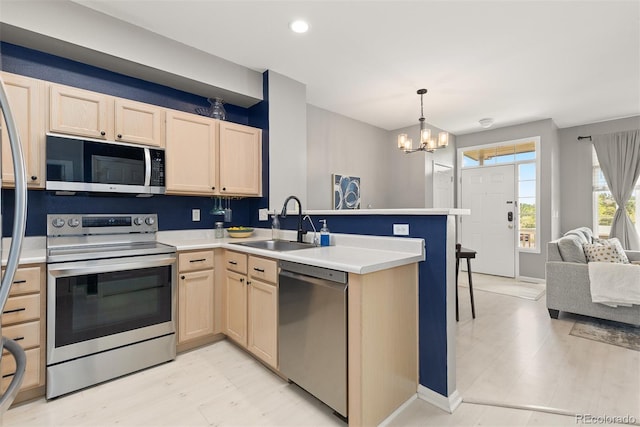 5555 E Briarwood Ave Unit 1404, Centennial, CO 80122 - kitchen with stainless steel appliances, light brown cabinetry, a sink, a peninsula, and a chandelier