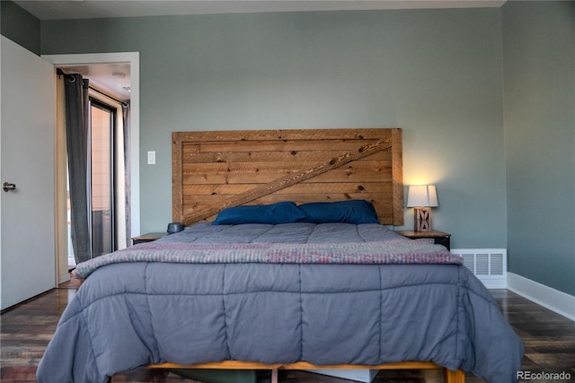 bedroom with visible vents, baseboards, and wood finished floors