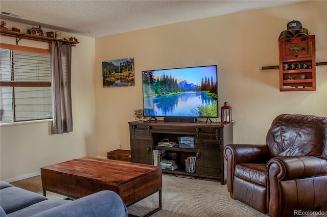 living area featuring visible vents, baseboards, carpet, and a textured ceiling