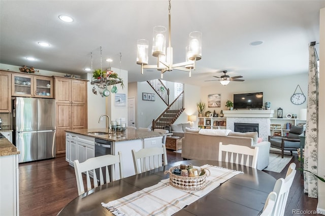 21502 E Idyllwilde Dr, Parker, CO 80138 - dining room with ceiling fan, dark wood-type flooring, a glass covered fireplace, recessed lighting, and stairway