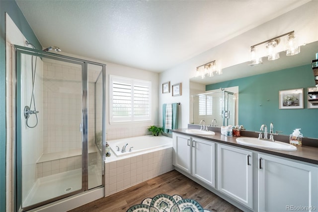 21502 E Idyllwilde Dr, Parker, CO 80138 - bathroom with a stall shower, a bath, wood finished floors, and double vanity