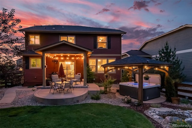 21502 E Idyllwilde Dr, Parker, CO 80138 - back of house at dusk featuring a hot tub, a gazebo, a patio, and a lawn