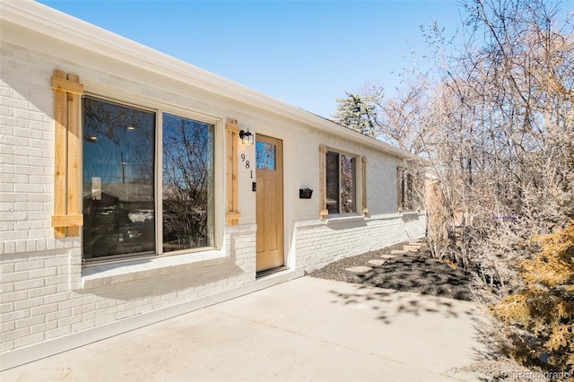 property entrance featuring brick siding