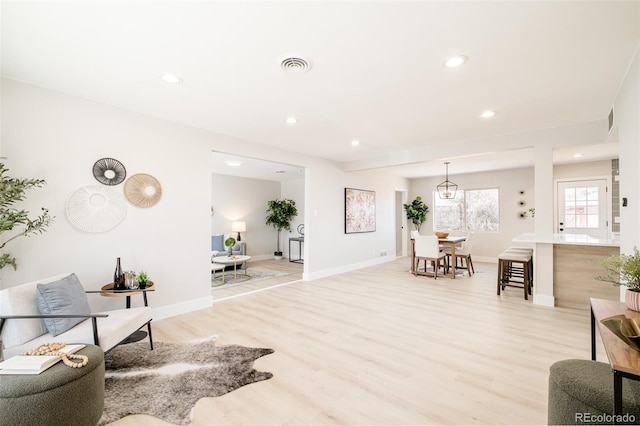 living room featuring recessed lighting, visible vents, light wood-style flooring, and baseboards