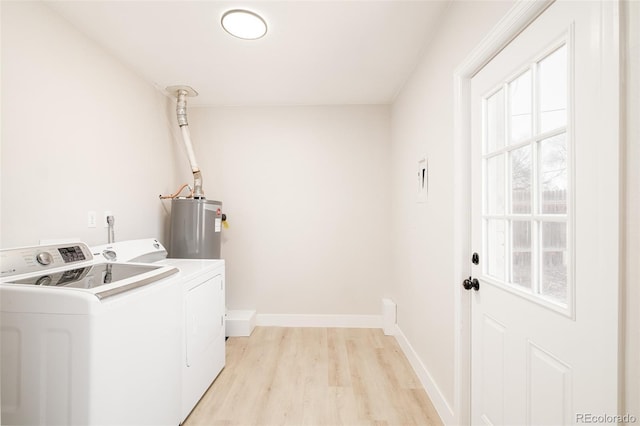 washroom featuring laundry area, baseboards, water heater, light wood-style floors, and independent washer and dryer