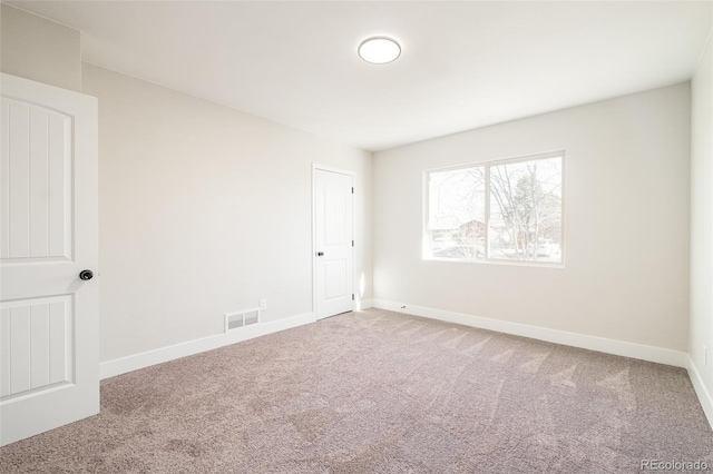 unfurnished room featuring carpet, visible vents, and baseboards