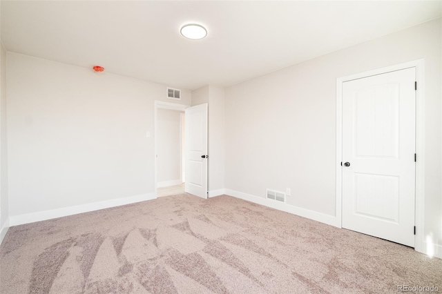 unfurnished room with baseboards, visible vents, and carpet flooring