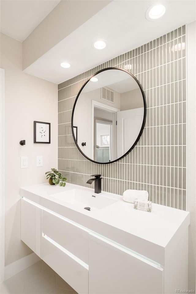 bathroom featuring tile walls, vanity, visible vents, backsplash, and tile patterned floors