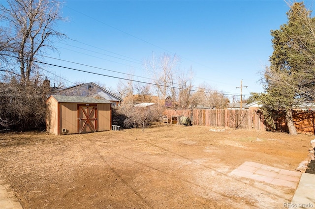 view of yard featuring a shed, an outdoor structure, and fence