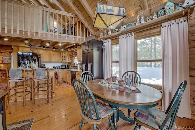 dining space with wooden walls, high vaulted ceiling, light hardwood / wood-style flooring, wooden ceiling, and beamed ceiling