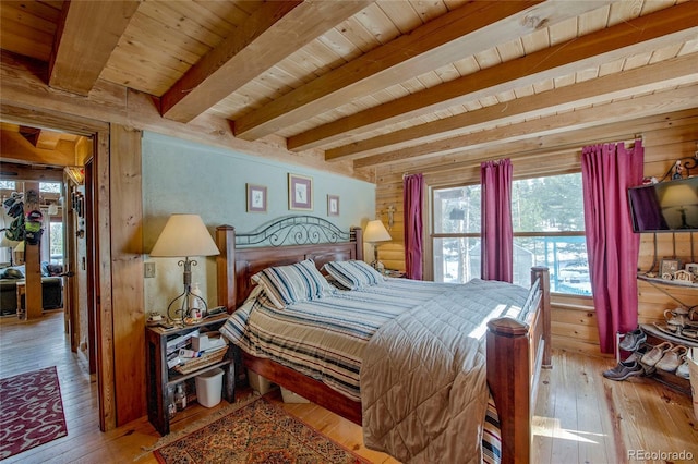 bedroom featuring wood walls, beam ceiling, wood ceiling, and light hardwood / wood-style flooring