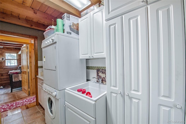 washroom with cabinets, wood ceiling, sink, light tile patterned floors, and stacked washer and clothes dryer