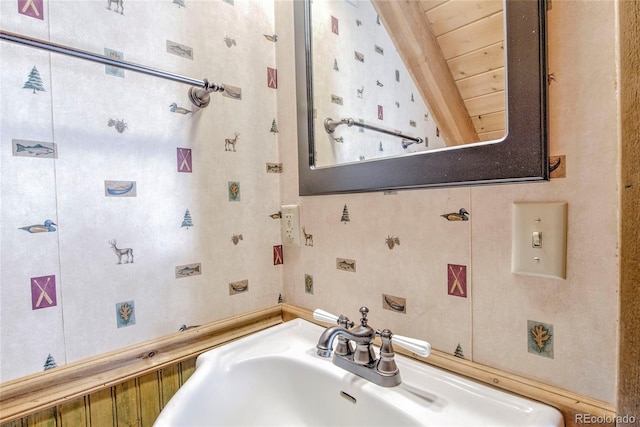 bathroom featuring beam ceiling, wooden ceiling, and sink