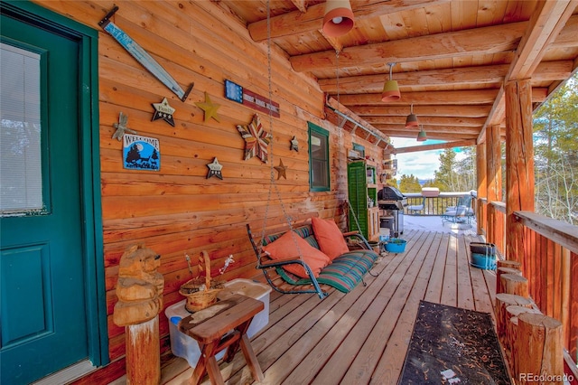 wooden deck featuring area for grilling and a porch